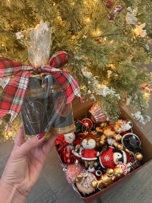 Izzo’s Season holiday seasoning gift set with plaid bow held in front of Christmas tree and ornaments.