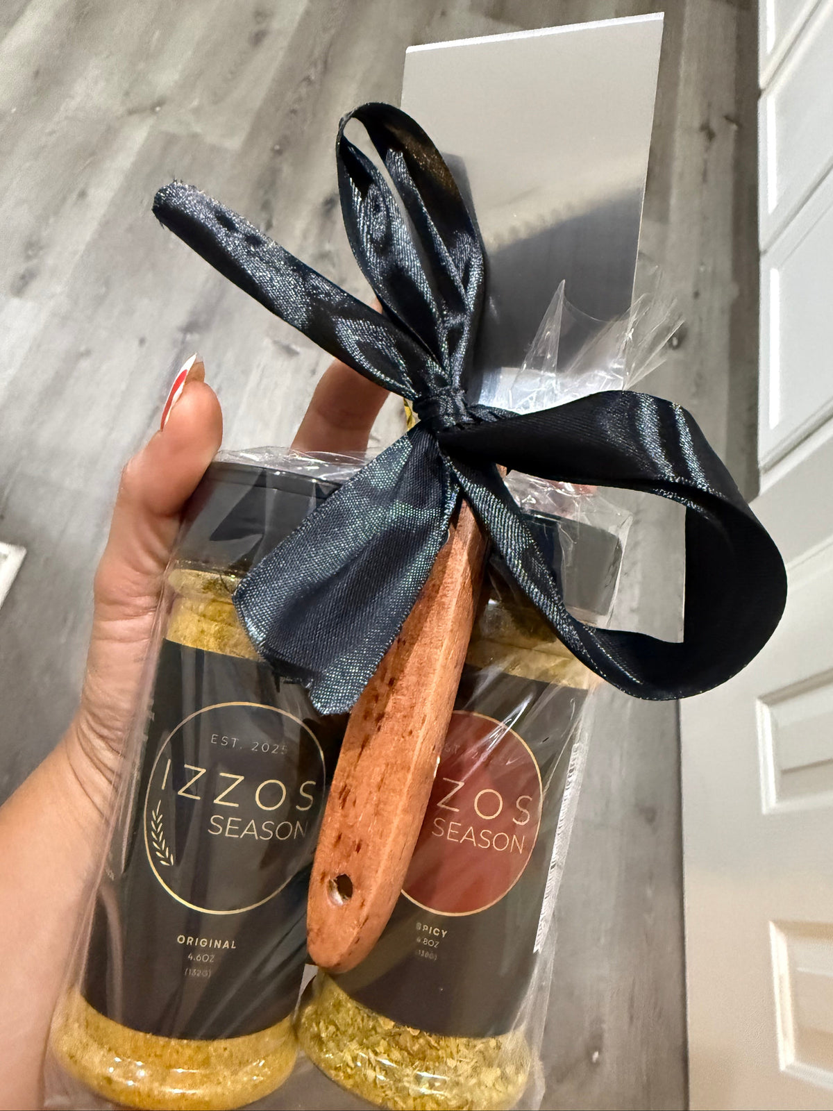 Izzo's Season gift set featuring Original and Spicy all-purpose seasonings with a wooden grill scraper, wrapped for gifting.